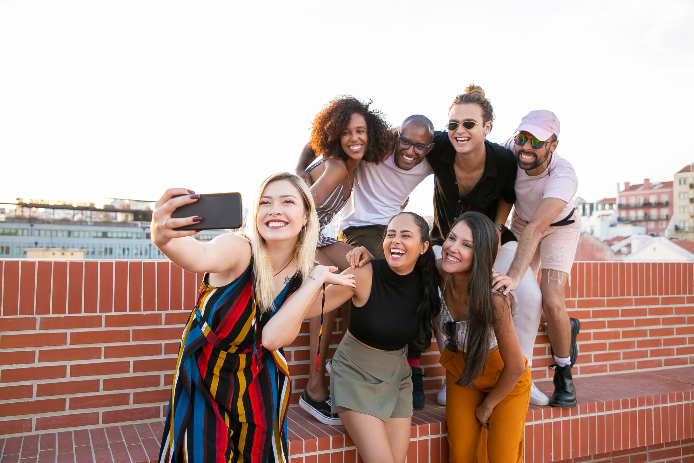 chosen family, biological family, building a chosen family, moms, family, family life, family advice, build your own tribe, Excited young diverse men and women taking selfie on rooftop